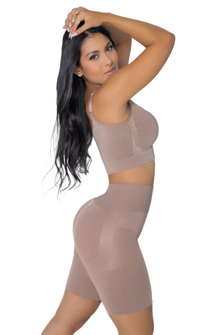 Woman modeling a pair of beige, high-waisted, seamless shapewear shorts with a push-up effect by Jackie London